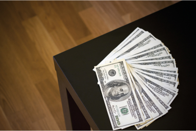 $100 bills fanned out on coffee table