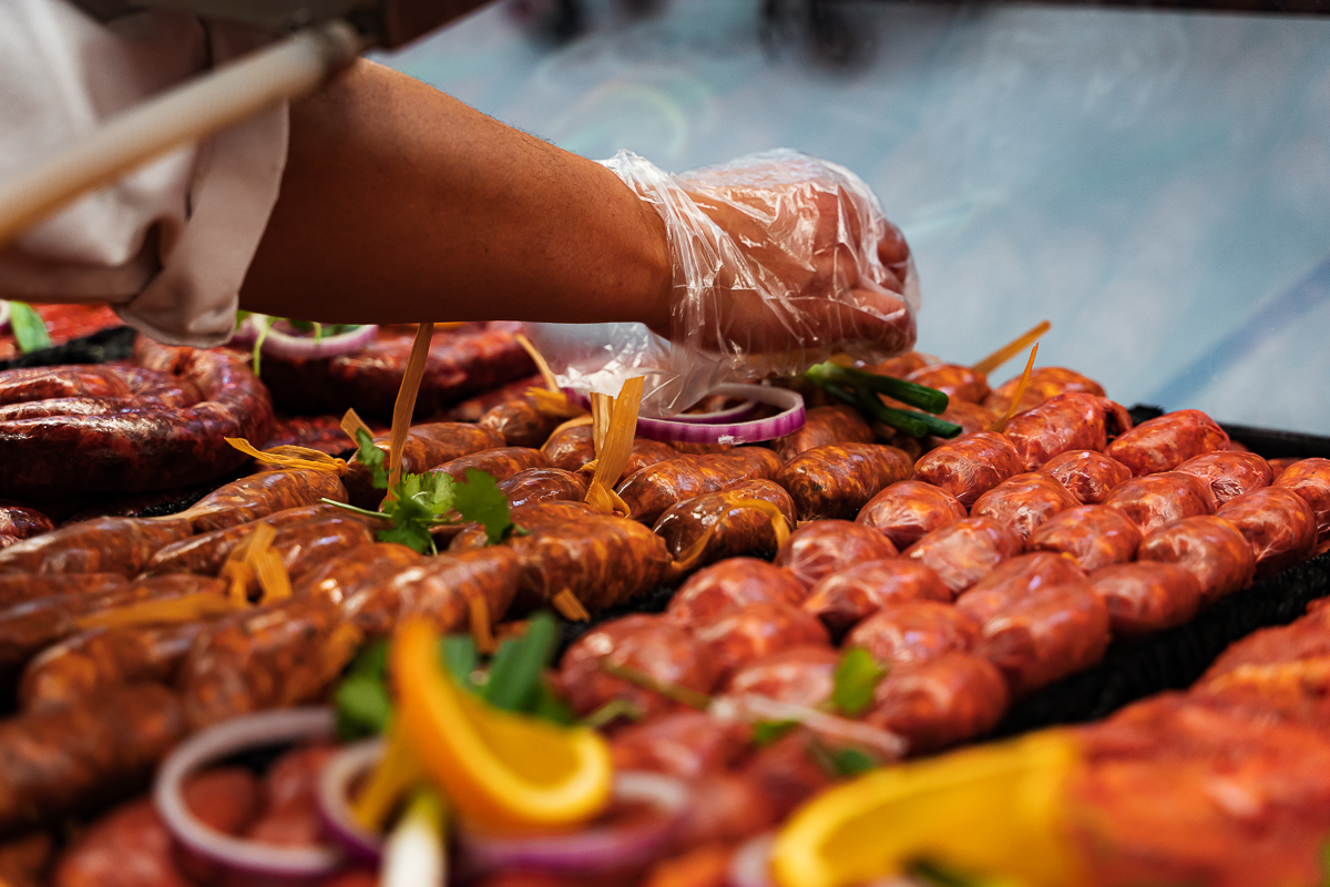A variety of chorizo being prepared and marinated with vegetables