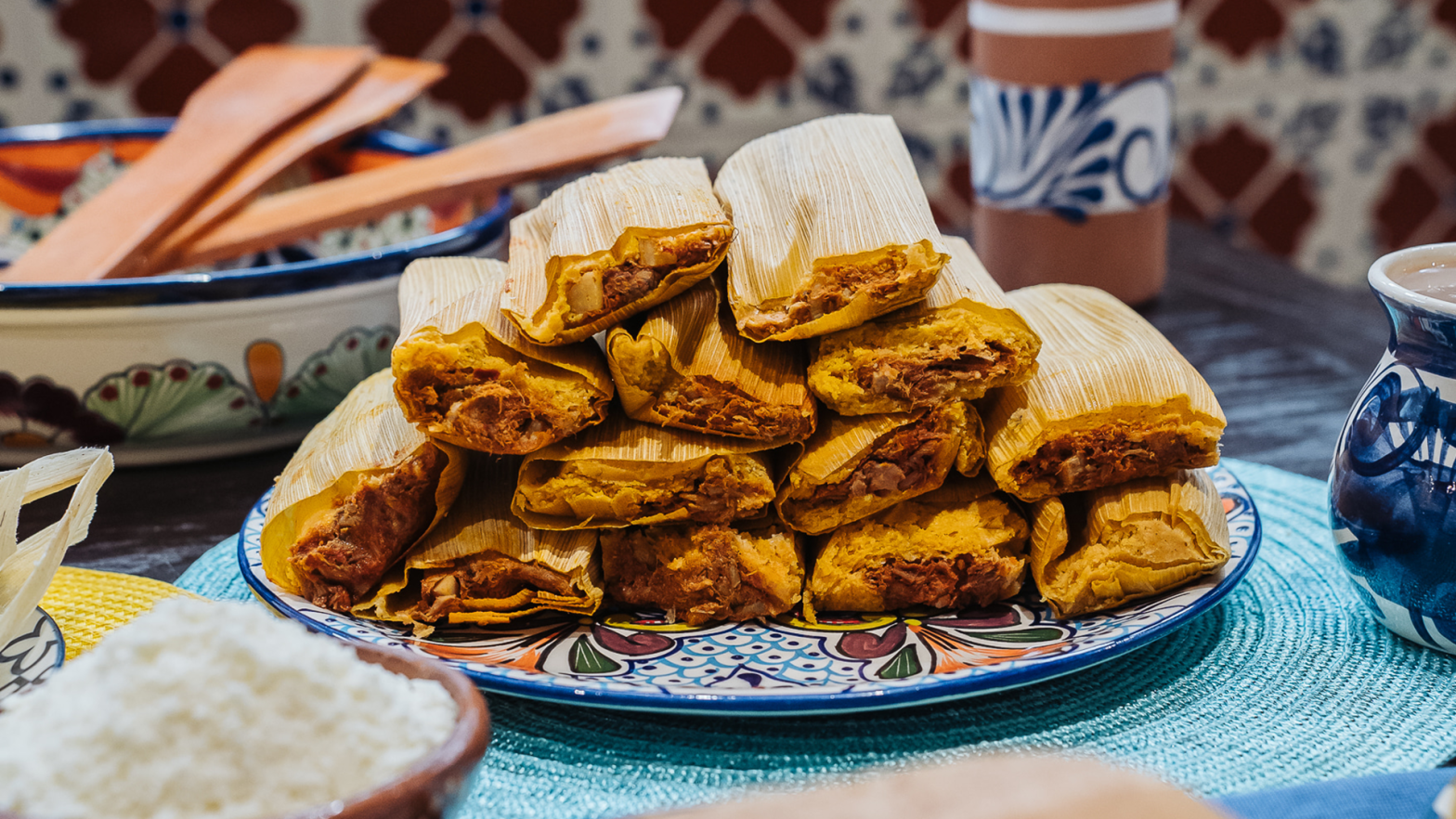 A dish stacked with freshly-made tamales