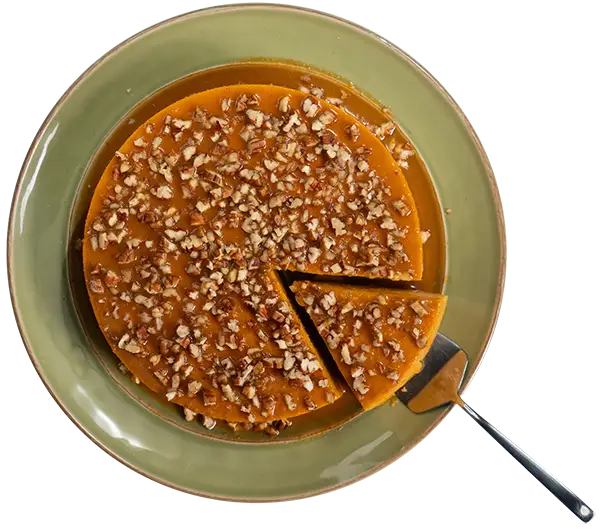 Flan with pecans sprinkled on top, served on a plate