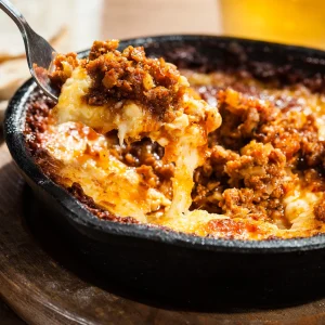 Chorizo queso fundido with melted Monterey Jack cheese and browned pork chorizo served in a cast iron skillet.