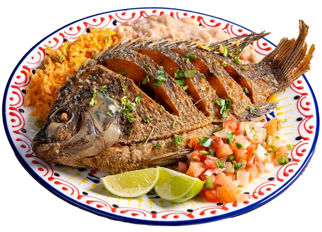 Fried whole mojarra served with rice, refried beans, pico de gallo, and lime wedges